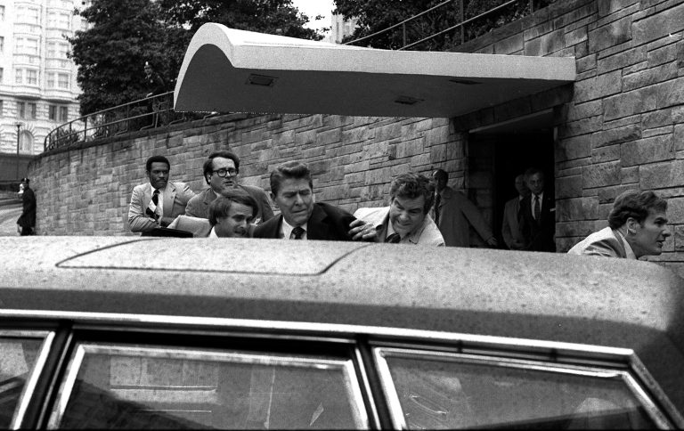 In this March 30, 1981 file photo, former President Ronald Reagan, center, is shown being shoved into the president's limousine by secret service agents after being shot outside a Washington hotel.