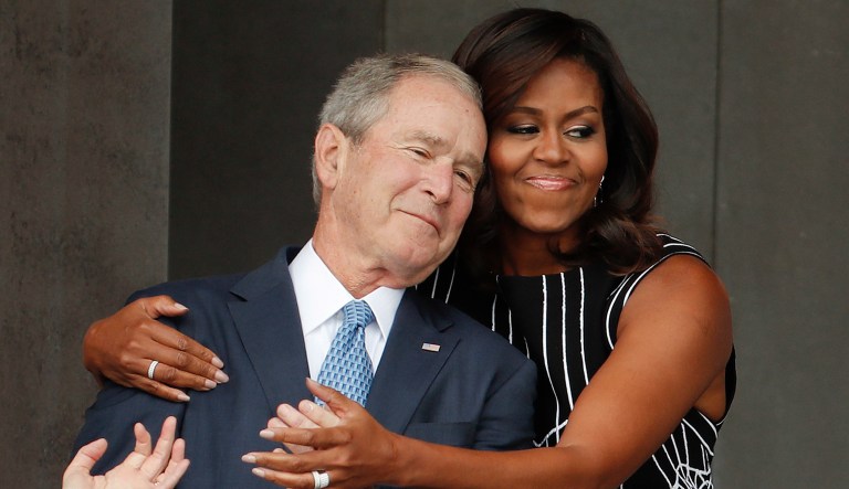 First lady Michelle Obama hugs former President George W. Bush during the dedication ceremony for the Smithsonian Museum of African American History and Culture on the National Mall in Washington, Saturday, Sept. 24, 2016. 
