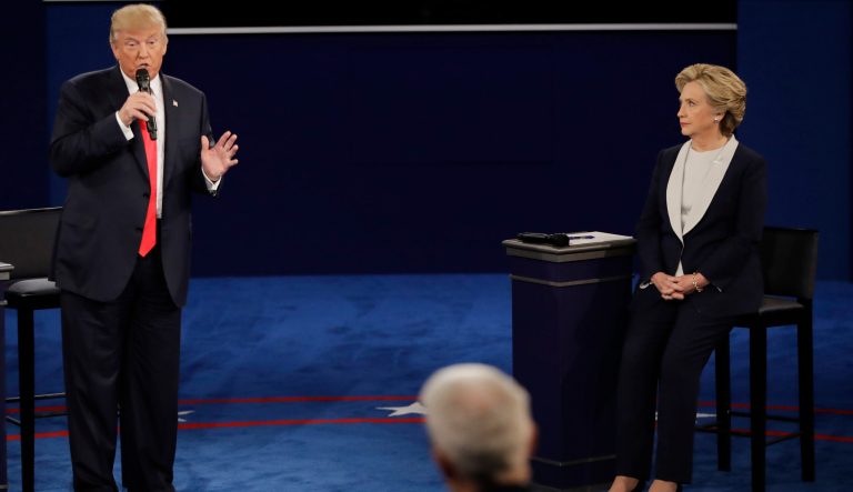 Republican presidential nominee Donald Trump answers a question as Democratic presidential nominee Hillary Clinton listens during the second presidential debate at Washington University in St. Louis, Sunday, Oct. 9, 2016. 