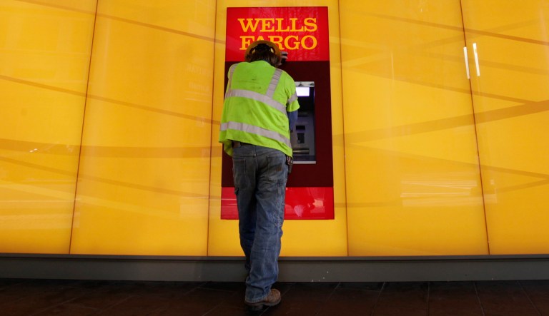 FILE - In this Tuesday, Jan. 17, 2012, file photo, a customer uses an ATM outside a Wells Fargo branch in Charlotte, N.C. Newly appointed Wells Fargo CEO Tim Sloan told employees Tuesday, Oct. 25, 2016, that he is "sorry for the pain" that the bank's employees have suffered as a result of the company's sales practices scandal. 