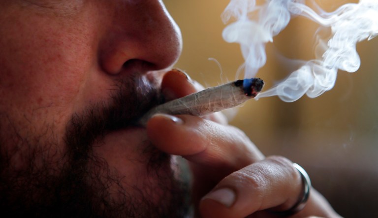 In this Nov. 21, 2014, file photo, a former U.S. Marine smokes medical marijuana in Belfast, Maine.