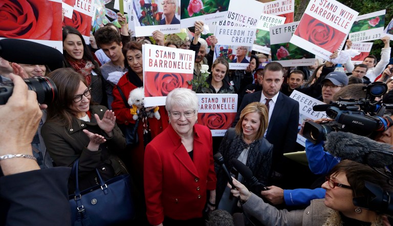 Barronelle Stutzman, center, a Richland, Wash., florist who was fined for denying service to a gay couple in 2013, smiles as she is surrounded by supporters. Stutzman was sued for refusing to provide services for a same sex-wedding and says she was exercising her First Amendment rights.