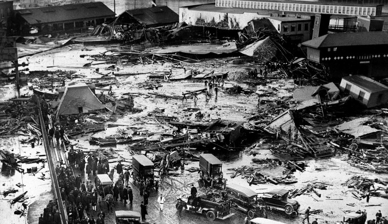 In this Jan. 15, 1919, file photo, the ruins of tanks containing 2 1/2 million gallons of molasses lie in a heap after an eruption that hurled trucks against buildings and crumpled houses in the North End of Boston.