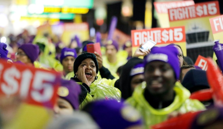 A woman shouts while marching with service workers asking for $15 minimum wage during a rally at Newark Liberty International Airport, Tuesday, Nov. 29, 2016, in Newark, N.J.