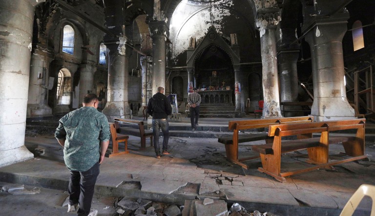 Iraqi Christians inspect a church damaged by Islamic State fighters during their occupation of Hamdaniyah, near Mosul, Iraq.