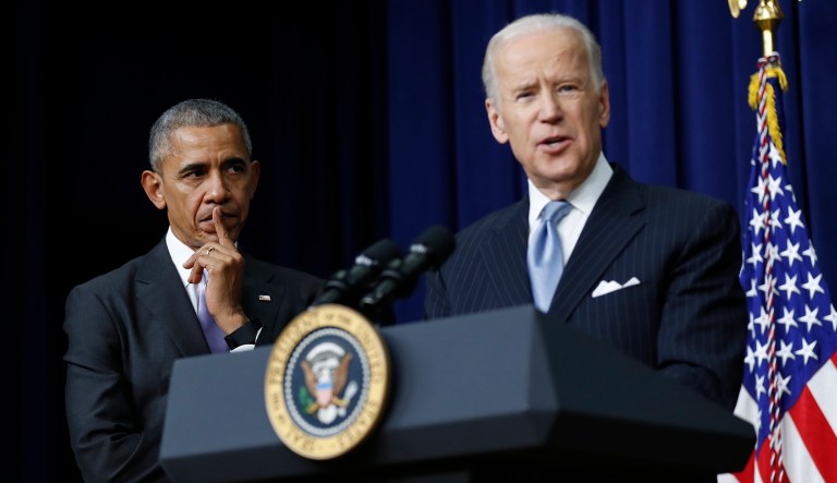 Barack Obama listens as Joe Biden speaks in the South Court Auditorium in the Eisenhower Executive Office Building on the White House complex in Washington.