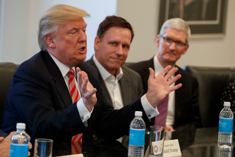 Apple CEO Tim Cook, right, and PayPal founder Peter Thiel, center, listen as President-elect Donald Trump speaks during a meeting with technology industry leaders at Trump Tower in New York, Wednesday, Dec. 14, 2016.