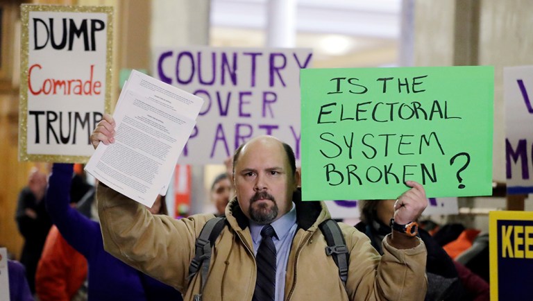 Brock Ervin holds a sign outside the Indiana House chamber at the Statehouse.