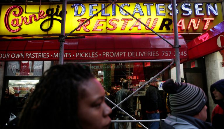 People wait in line to eat at the Carnegie Delicatessen in New York, Thursday, Dec. 29, 2016. After 79 years of serving up heaps of cured meat, the Carnegie slices its last ridiculously oversized sandwich Friday.