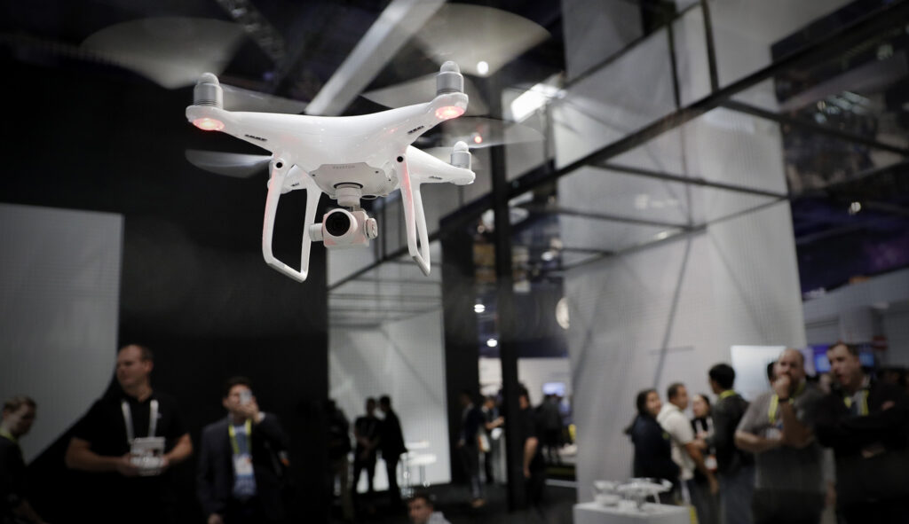 People watch a flying demonstration of a drone at the DJI booth at CES International in Las Vegas. 