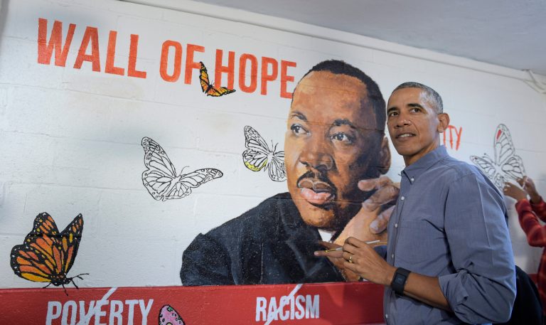 President Barack Obama helps paint a mural of Martin Luther King Jr., in the community room of the Jobs Have Priority Naylor Road Family Shelter in Washington, Monday, Jan. 16, 2017. The mural,"Wall of Hope" was created by artist Omatayo Akinbolajo and features a painting of Martin Luther King Jr.