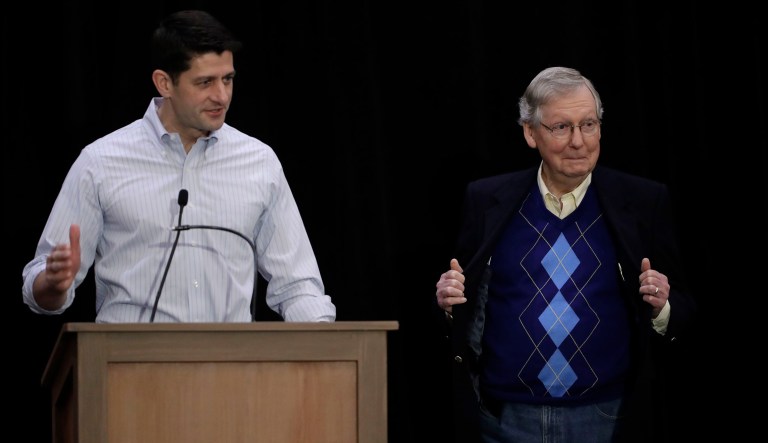 Senate Majority Leader Mitch McConnell of Ky., right, opens his coat to show his sweater as House Speaker Paul Ryan of Wis., speaks with members of the media during a news conference at the Republican congressional retreat in Philadelphia, Thursday, Jan. 26, 2017.