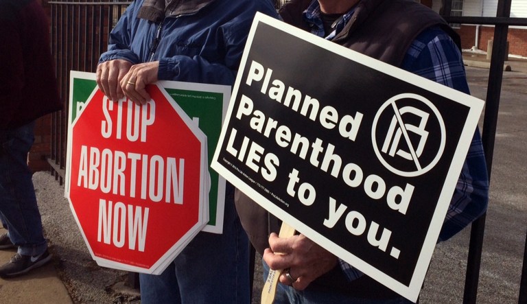 Marvin Naegele, 62, of Walnut, Iowa, left,  and Lon Schroeder, 61, of Council Bluffs  hold protest signs during a protest on Saturday, Feb. 11, 2017 in Council Bluffs, Iowa.  Rallies aimed at urging Congress and President Donald Trump to end federal funding for Planned Parenthood are scheduled across the country.