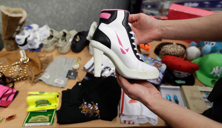 In this Wednesday. Feb. 22, 2017 photo, seized counterfeit items, including a fake Nike high heeled shoe, are displayed to be photographed at UK Border Force offices in London.  In the past five years, the Border Force, the policing command under Britainâs Home Office charged with immigration and customs controls, has seized thousands of consignments at Heathrow alone, valued at around Â£100 million ($125 million).