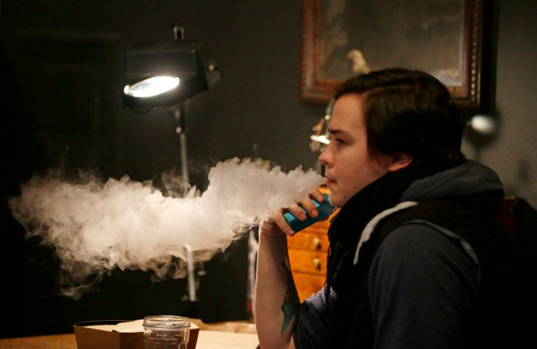 A person vapes after taking a lunch break in the Future Vapor store in Seattle.