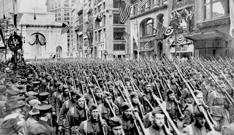 In this 1919 file photo, soldiers of the US Army 308th Infantry march up New York's Fifth Avenue just past the Arch of Victory during spring of 1919.