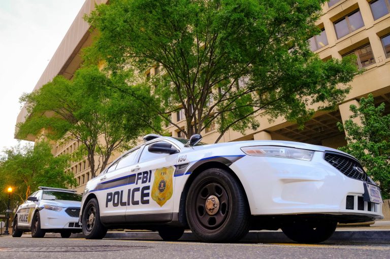 In this photo, FBI police vehicles are parked next to the J. Edgar Hoover FBI headquarters building early in the morning in Washington.