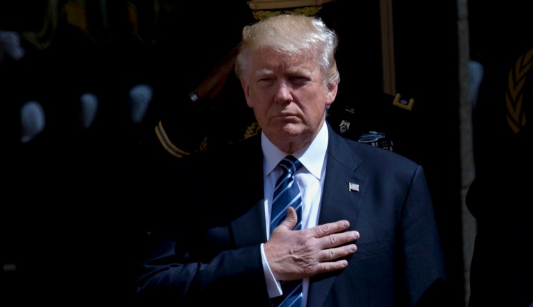 President Trump stands for the national anthems during a ceremony. 