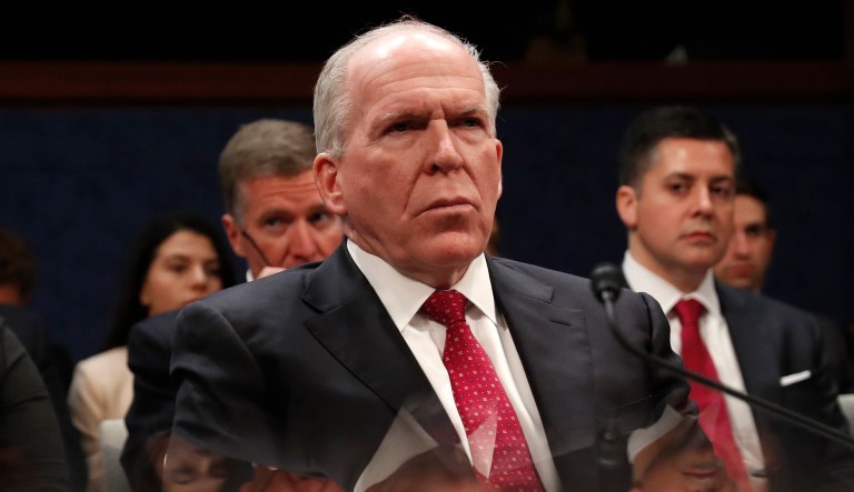 Former CIA Director John Brennan is reflected in a table as he prepares to testify on Capitol Hill in Washington, Tuesday, May 23, 2017, before the House Intelligence Committee Russia Investigation Task Force.