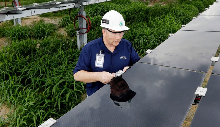 A man works on solar panels in Gibsonton, Fla.