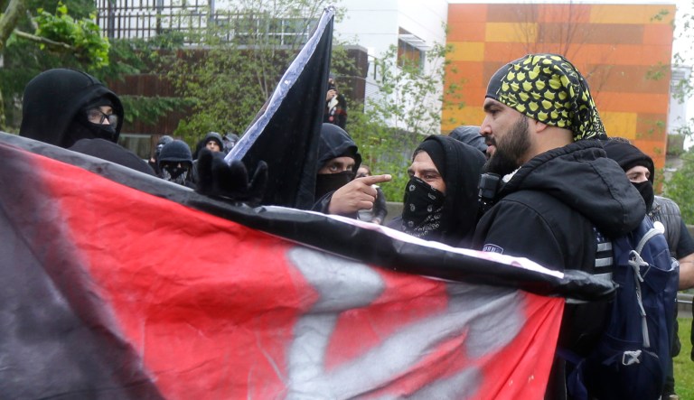 Counter-protesters at left confront a man protesting with the conservative group Patriot Prayer, right, Thursday, June 15, 2017, at Evergreen State College in Olympia, Wash.