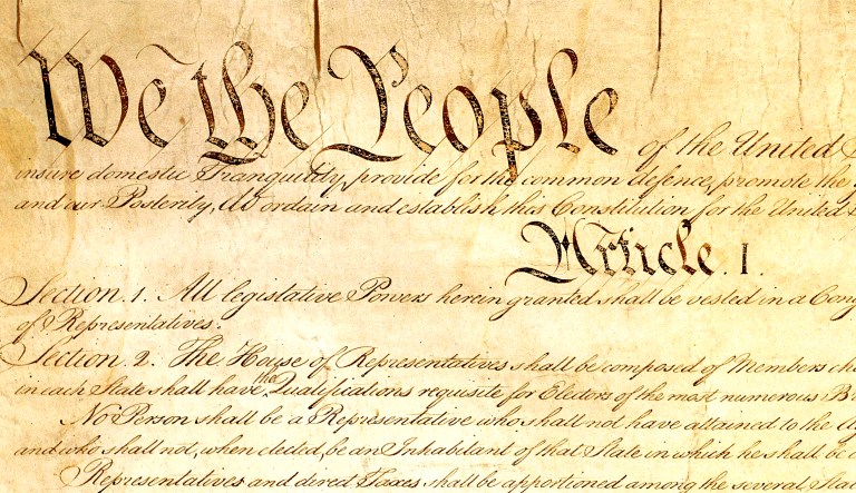 This photo made available by the U.S. National Archives shows a portion of the first page of the United States Constitution.