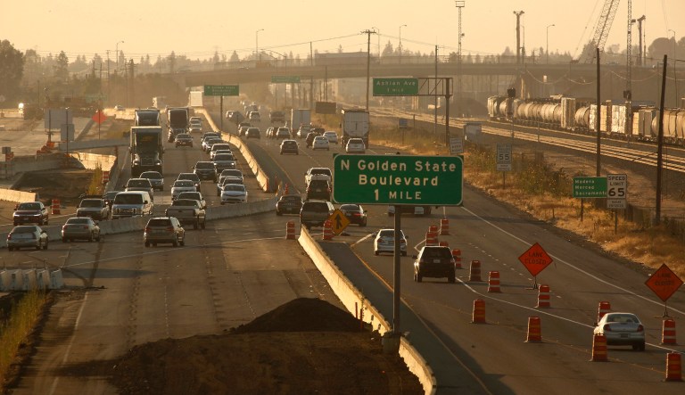 Cars and trucks roll along a section of Highway 99 during rush hour that's being worked on for the high-speed rail in Fresno, California.