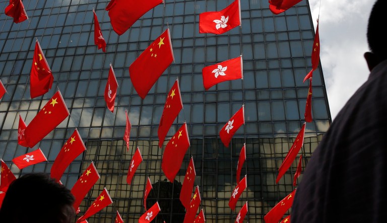 China and Kong Hong national flags are displayed outside a shopping center in Hong Kong.
