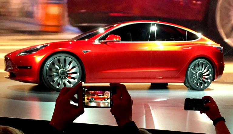 In this 2016 file photo, Tesla Motors unveils the new lower-priced Model 3 sedan at the Tesla Motors design studio in Hawthorne, Calif. Electric car maker Tesla said on Monday, July 3, 2017, that its Model 3 car will go on sale on Friday.