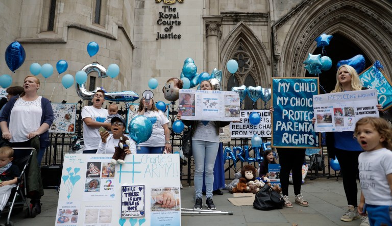 Supporters of critically ill baby Charlie Gard shout and hold placards before his parents Connie Yates and Chris Gard arrived at the High Court in London.