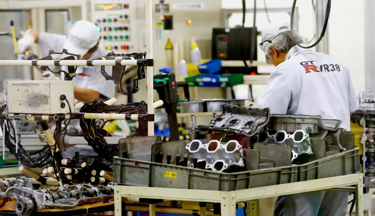 Nissan Motor Co. factory workers check parts of engines on an assembly line at its plant in Yokohama, near Tokyo.