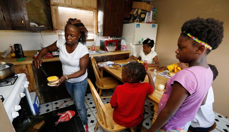 Otibehia Allen prepares dinner for her children in their rented mobile home in the same isolated, low-income community of Jonestown, Mississippi, where she grew up among the cotton and soybean fields of the Mississippi Delta. Her children are on Medicaid, but Allen says a small pay raise meant she lost her own coverage through the federal and state health insurance program.