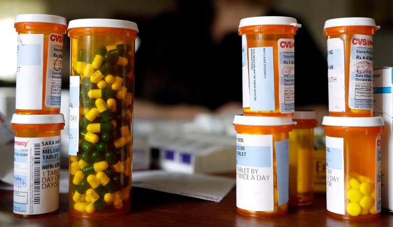 Sara Hayden poses for a photo with some of her rheumatoid arthritis medications at home in Half Moon Bay, Calif.