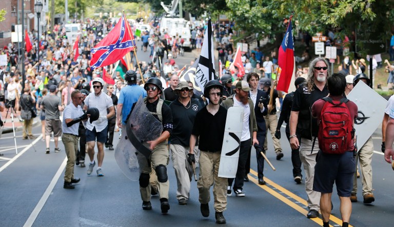 White nationalist demonstrators walk through town after their rally was declared illegal near Lee Park in Charlottesville, Va., Saturday, Aug. 12, 2017.