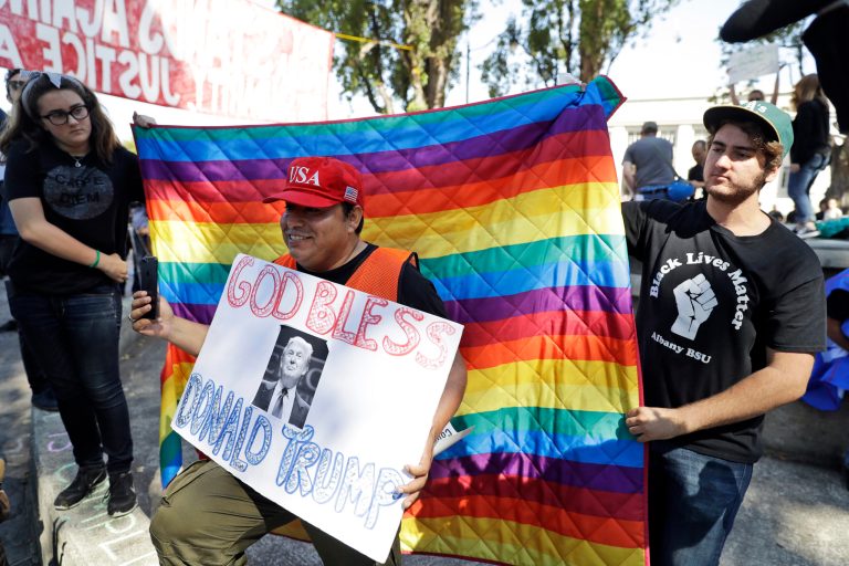 Donald Trump supporter Marco Gutierrez, center, is draped with a rainbow flag by Finley Mink, left, and her brother Cole during a free speech rally Sunday, Aug. 27, 2017, in Berkeley, Calif. Protesters gathered for a âRally Against Hateâ in response to a planned right-wing protest that raised concerns of clashes and prompted a large police presence.