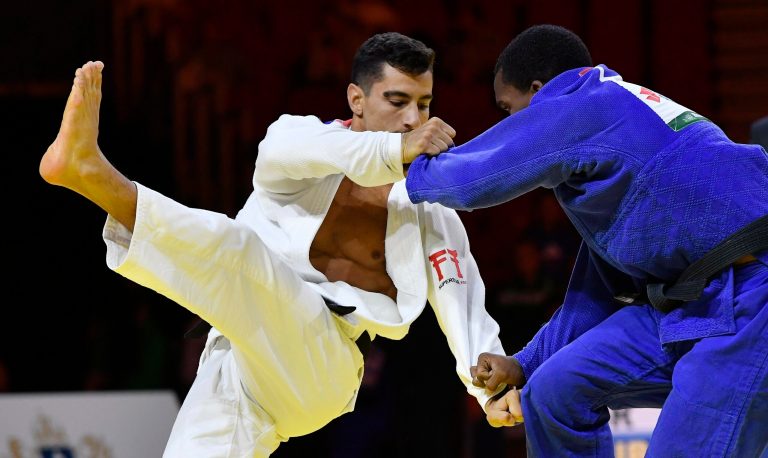 Osines Solis, in blue, of Cuba and Tal Flicker of Israel fight in the men's 66kg category.