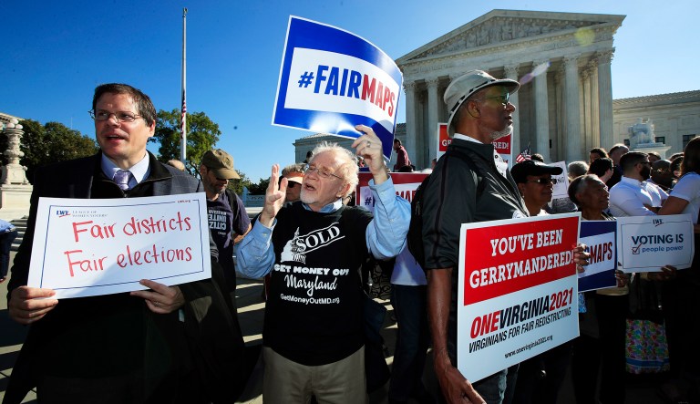 Eric Silberman from Silver Spring, Md., from left, Charlie Cooper from Baltimore, Md., and Clay Wilson from Alexandria, Va., join others in a rally for a fair election outside the U.S. Supreme Court in Washington, Tuesday, Oct. 3, 2017. The Supreme Court hears arguments in a case about political maps in Wisconsin that could affect elections across the country.
