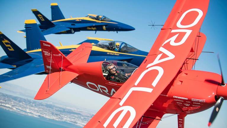 In advance of Fleet Week performances, Team Oracle aerobatics pilot Sean D. Tucker and U.S. Navy Blue Angels fly over the San Francisco Bay.