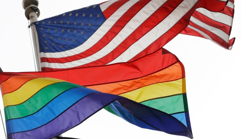 The Rainbow Flag flies beneath the American flag at the Stonewall National Monument, Wednesday, Oct. 11, 2017, in New York. The Rainbow Flag, an international symbol of LGBT liberation and pride, was flown for the first time at the monument.