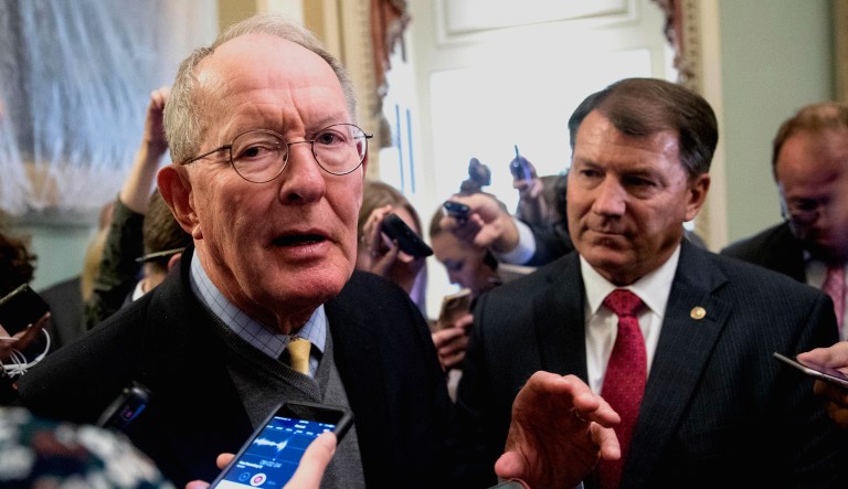 Sen. Lamar Alexander, R-Tenn., left, accompanied by Sen. Mike Rounds, R-S.D., right, speaks to reporters on Capitol Hill.