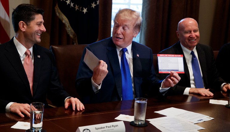 President Trump holds an example of what a new tax form may look like during a meeting on tax policy with Republican lawmakers in the Cabinet Room of the White House on Nov. 2, 2017.