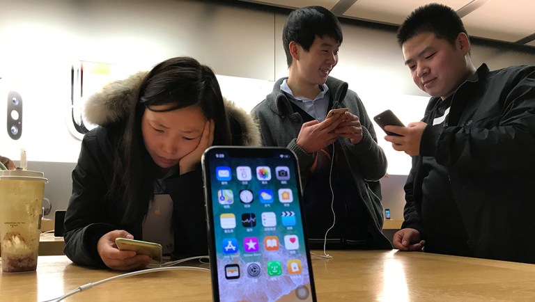 Shoppers check out the iPhone X at an Apple store in Beijing, China.