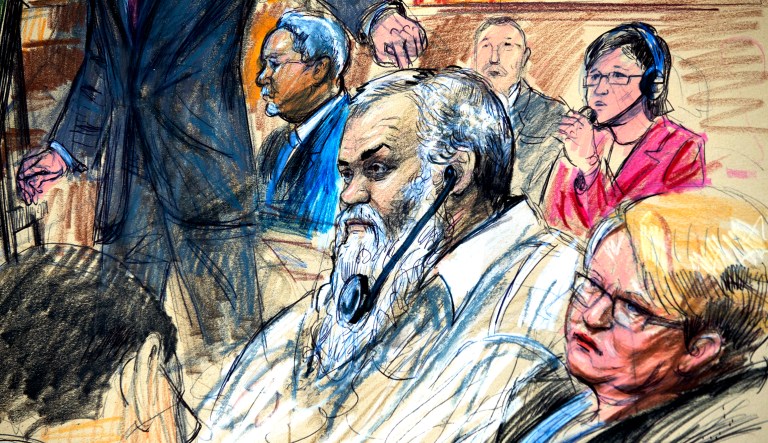 This Oct. 2, 2017, file courtroom sketch depicts Ahmed Abu Khattalah listening to a interpreter through earphones during the opening statement by assistant U.S. attorney John Crabb, second from left, at federal court in Washington, in the trial presided by U.S. District Judge Christopher Cooper. Defense attorney Jeffery Robinson, sits behind Crabb in a light blue suit and Michelle Peterson, also a member of the defense team, is at far right.