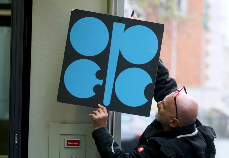 A worker attaches a poster of the Organization of the Petroleum Exporting Countries, OPEC, at their headquarters in Vienna, Austria, Wednesday, Nov. 29, 2017. With bills rising for gasoline or heating oil, consumers around the world are paying the price for a decision by OPEC and Russia last year to cut production. The strategy is working for those oil-producing nations and will likely be extended at a meeting Thursday.
