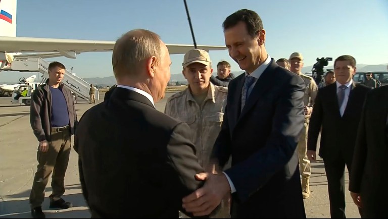 In this Monday, Dec. 11, 2017 frame grab made available by Russian Presidential TV Syrian President Bashar Assad, right, greets Russian President Vladimir Putin upon his arrival to the Hemeimeem air base in Syria. Declaring a victory in Syria, Putin on Monday visited a Russian military air base in the country and announced a partial pullout of Russian forces from the Mideast nation. Syrian President Bashar Assad is 4th at left.