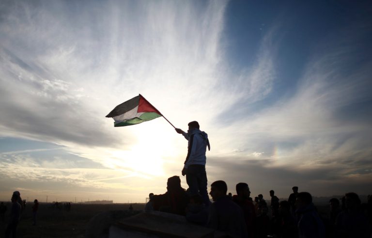 In this photo from 2017, a Palestinian protester waves a national flag during clashes on the Israeli border with Gaza.