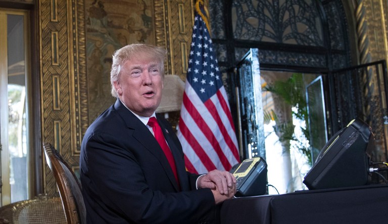 President Donald Trump turns to talk to the gathered media during a Christmas Eve video teleconference with members of the mIlitary at his Mar-a-Lago estate in Palm Beach, Fla., Sunday, Dec. 24, 2017.