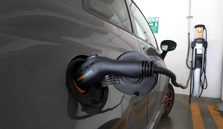 This April 25, 2016 photo shows an electric Fiat is plugged into a charging station in a parking lot in Los Angeles.