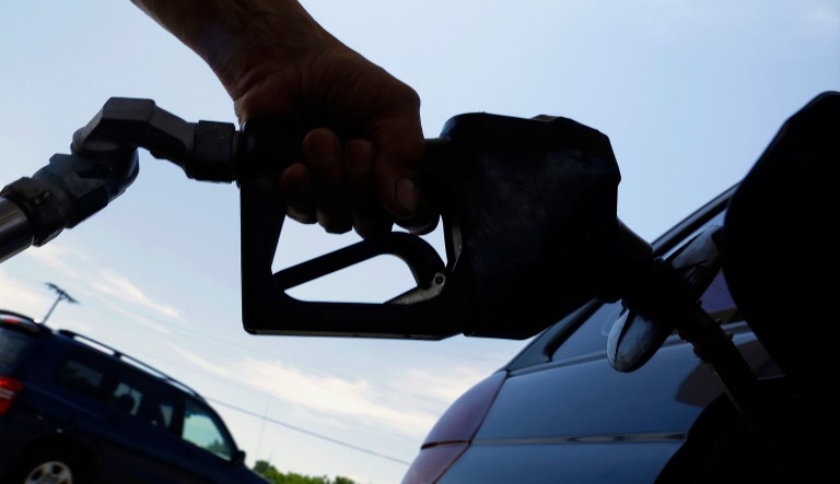 In this June 11, 2013, photo, a motorist puts fuel in his car's gas tank at a service station in Springfield, Ill.