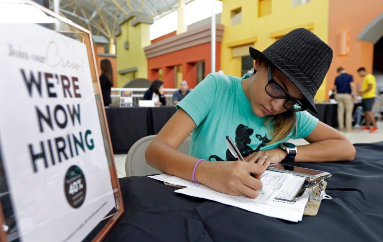 Job seeker Alejandra Bastidas fills out an application at a job fair at Dolphin Mall in Sweetwater, Fla.